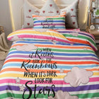 Colorful striped bed comforter with motivational quote on a bed