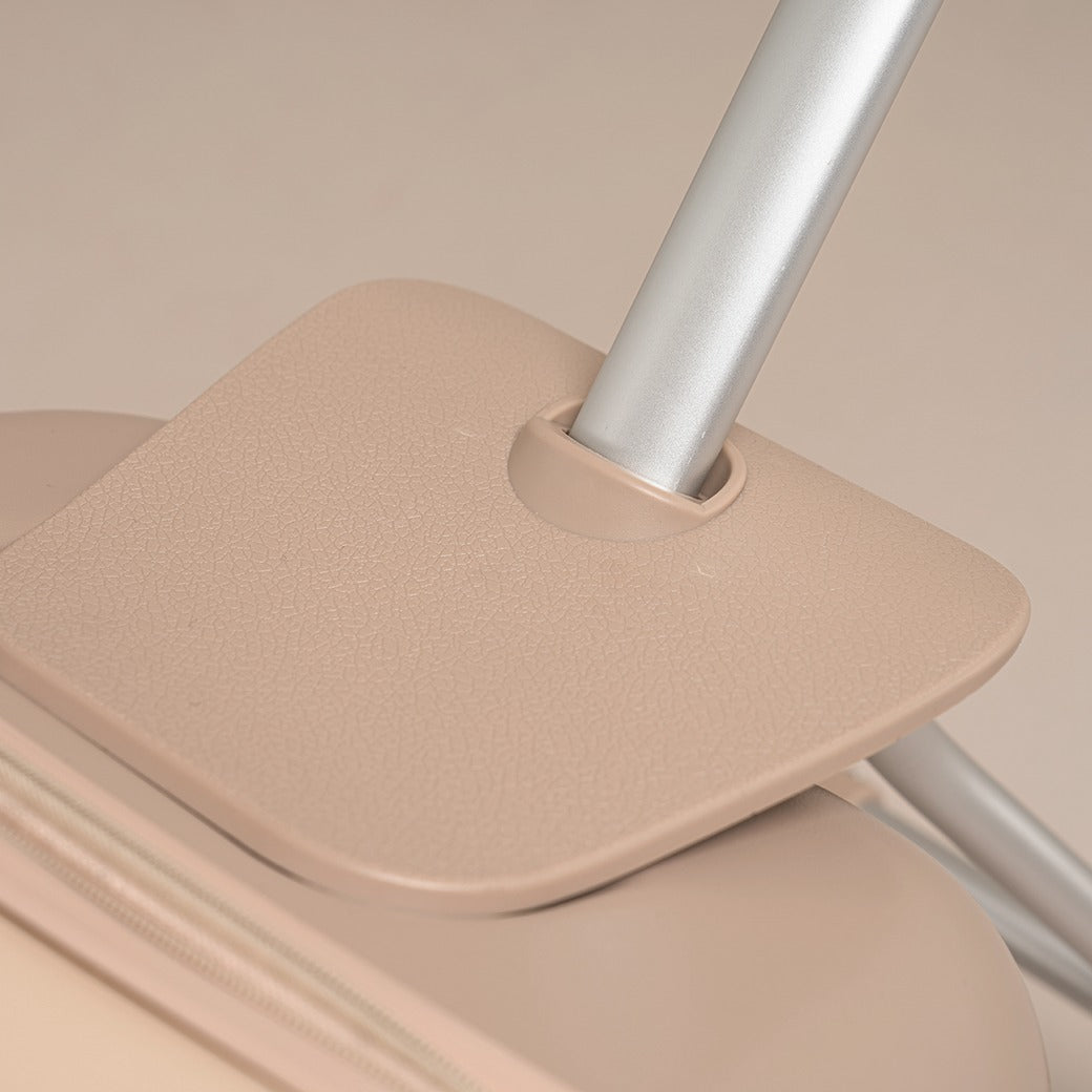 Beige suitcase with a handle on a beige background