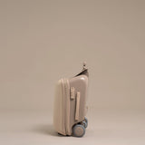 Beige suitcase with wheels on a beige background