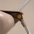 Close-up of a beige mop with a yellow wheel on a beige background