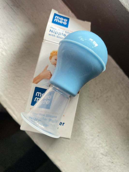 Blue baby bottle nipple with packaging on a textured surface