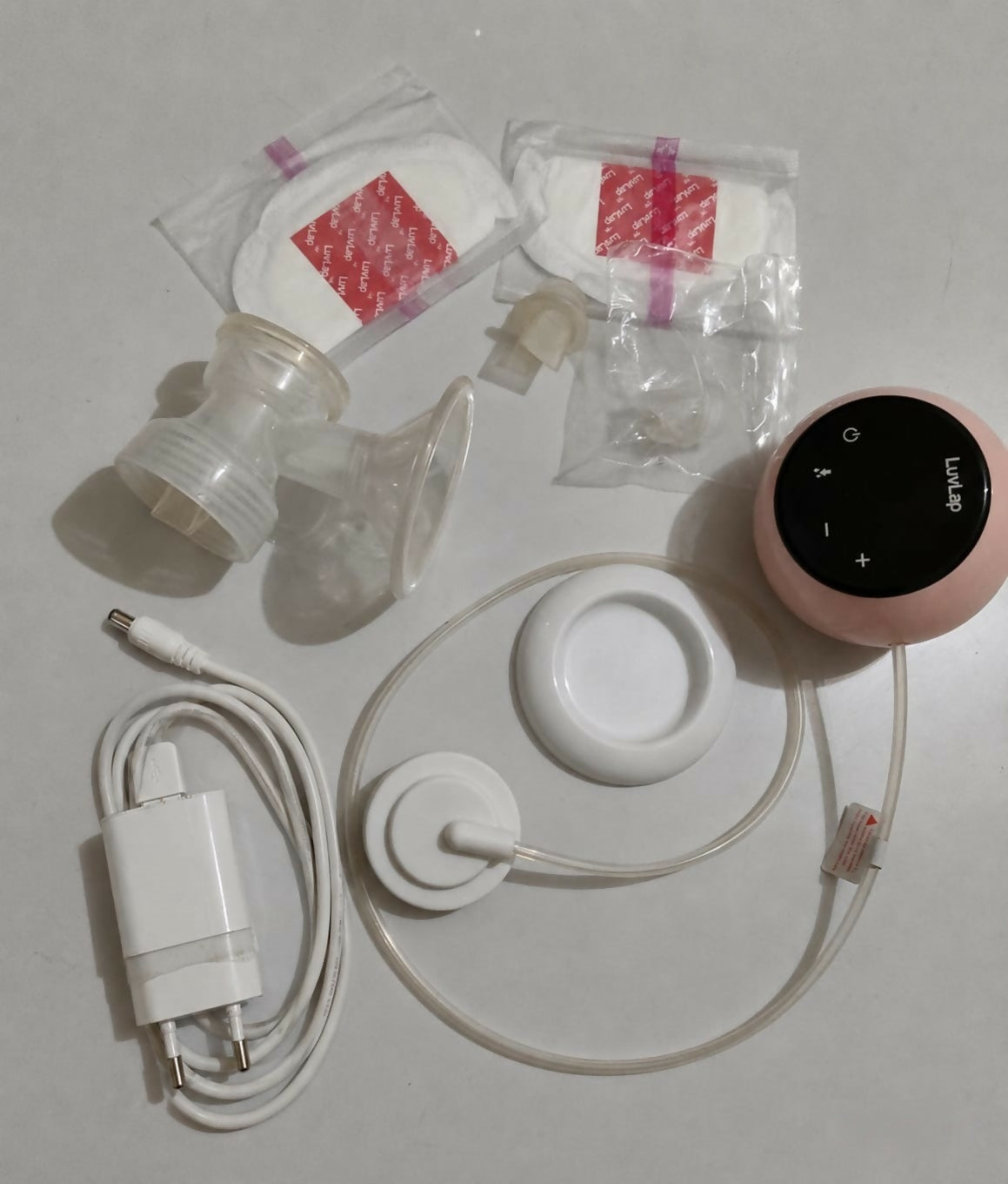 LUVLAP Adore single electric breast pump with adjustable suction settings, compact design, milk collection bottle, and comfortable pumping support for breastfeeding mothers.