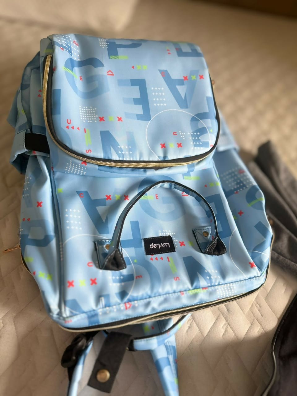LuvLap diaper bag with multiple storage compartments, insulated bottle pockets, comfortable shoulder straps, durable fabric, and a spacious design for carrying baby essentials during travel and daily outings.