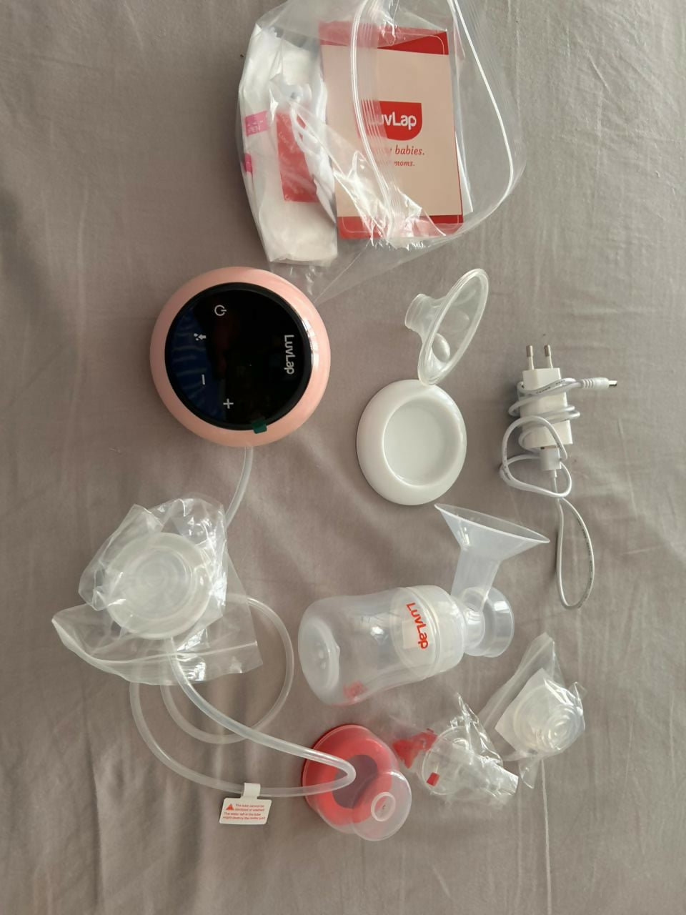 LuvLap Adore electric breast pump with adjustable suction, compact design, milk collection bottle, and comfortable pumping support for breastfeeding mothers.