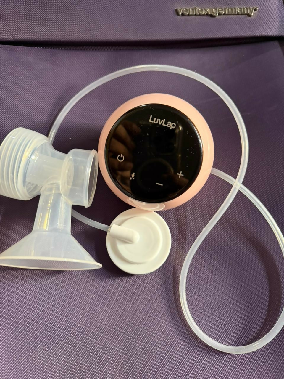 Breast pump with control panel on a purple surface