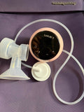 Breast pump with control panel on a purple surface