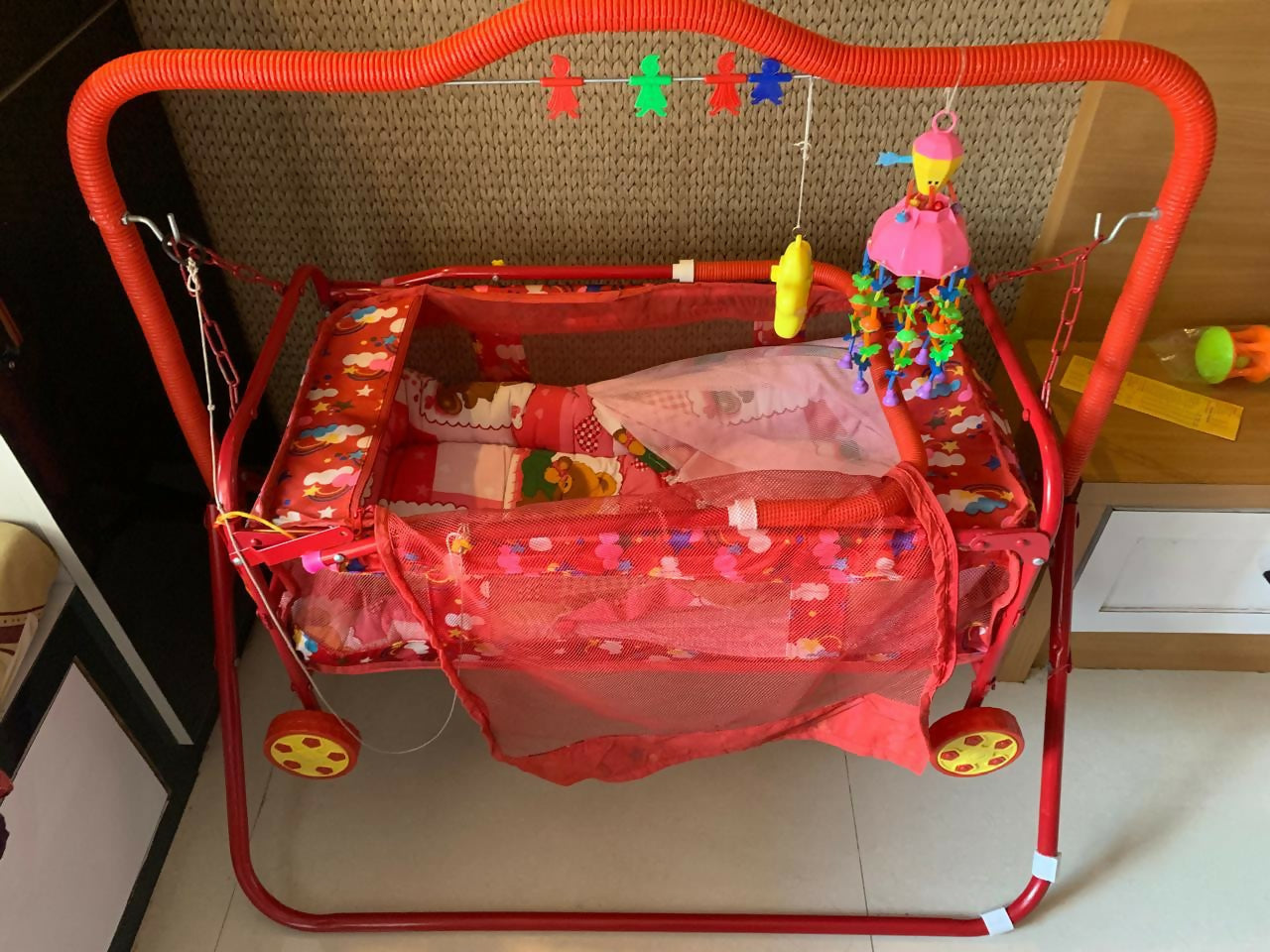 Manual baby jhula with mosquito net and mattress featuring gentle rocking motion, cozy sleeping space, protective mosquito net, cushioned mattress, and comfortable support for baby sleep.