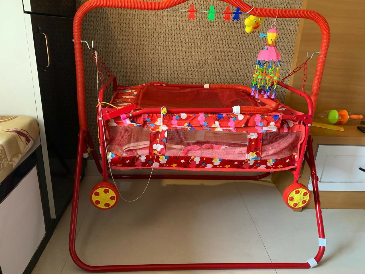 Manual baby jhula with mosquito net and mattress featuring gentle rocking motion, cozy sleeping space, protective mosquito net, cushioned mattress, and comfortable support for baby sleep.