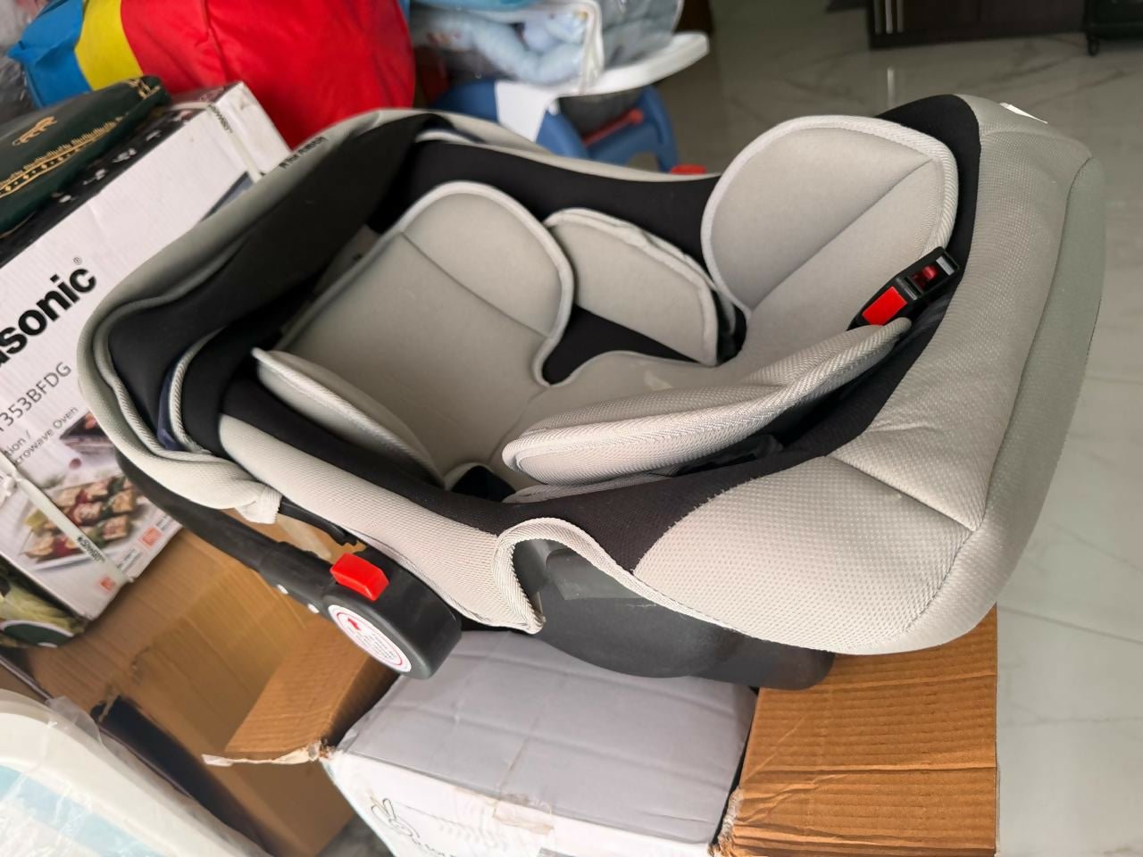 R for Rabbit Cozy Carry Cot/Car Seat with rear-facing design, cushioned seating, ergonomic carry handle, 5-point safety harness, and protective canopy for safe and comfortable travel with newborns and infants.