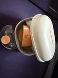 Set of travel-sized containers with a white case on a purple surface