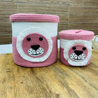 Two pink and white woven baskets with bear face designs 