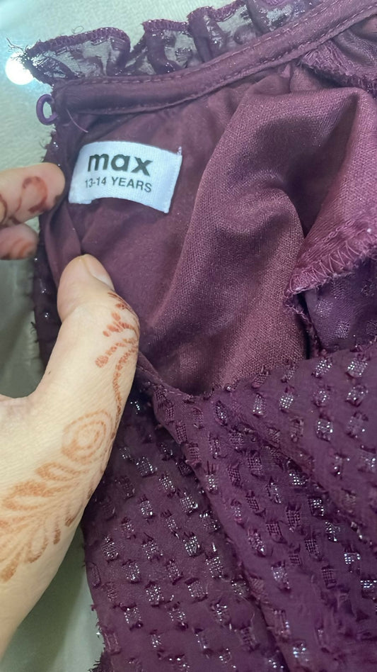 Close-up of a purple garment with a 'max' label on a blurred background