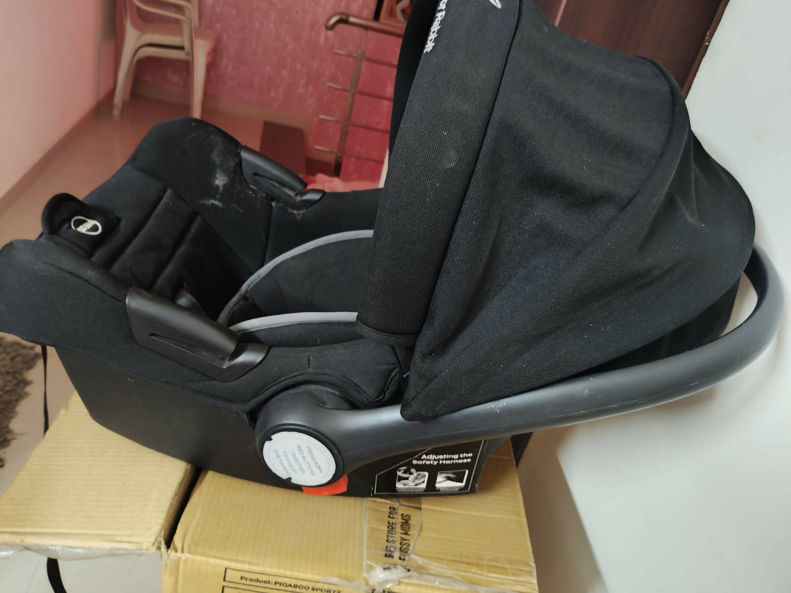 R for Rabbit Picaboo Sportz carry cot with cushioned seating, secure safety harness, portable carry handle, comfortable support, and travel-friendly design for babies.