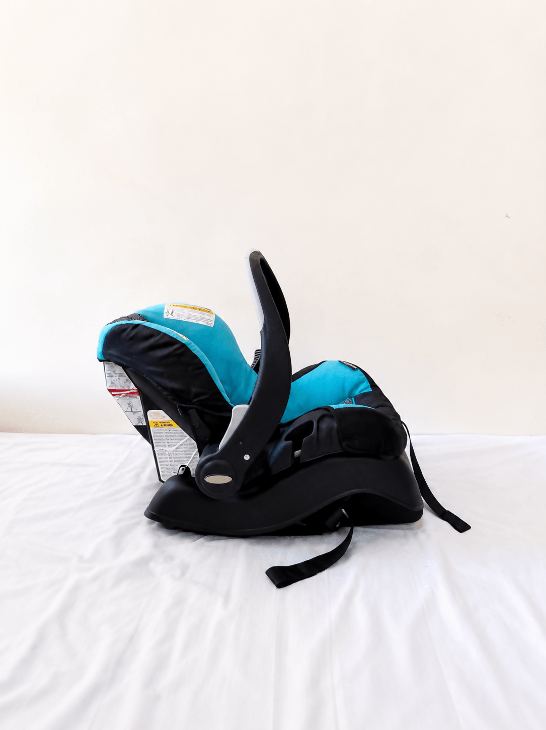 Evenflo Embrace infant car seat with base, rear-facing design, cushioned newborn support, secure safety harness, and portable baby carrier functionality for safe travel.