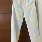 Tie-dye pants hanging against a wooden background