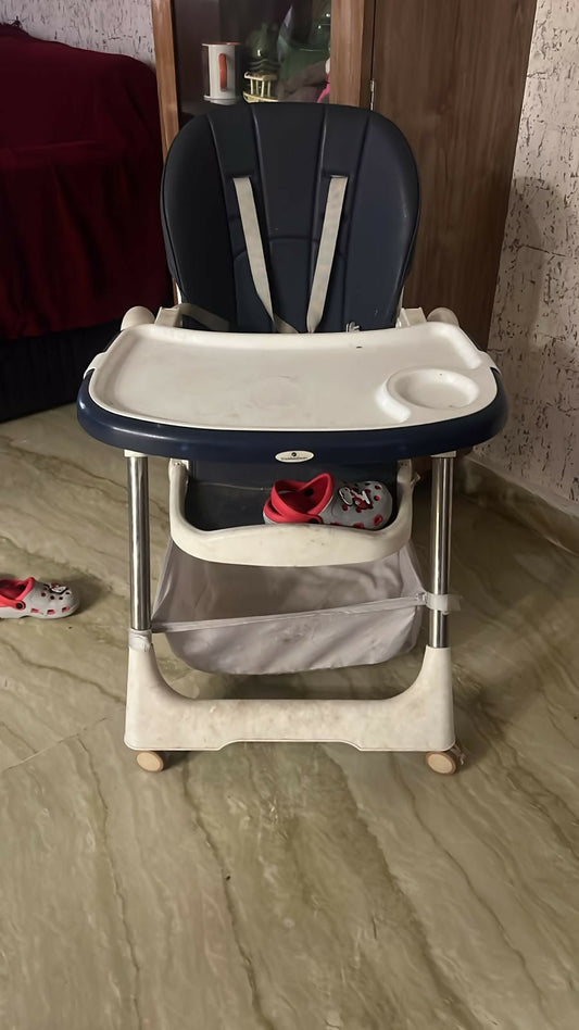 STAR AND DAISY Galaxy Star High Chair with comfortable padded seat, adjustable feeding tray, safety harness, sturdy frame, footrest, and easy-clean design for convenient baby and toddler mealtimes.