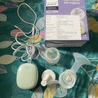 Philips Avent breast pump parts on a patterned fabric background