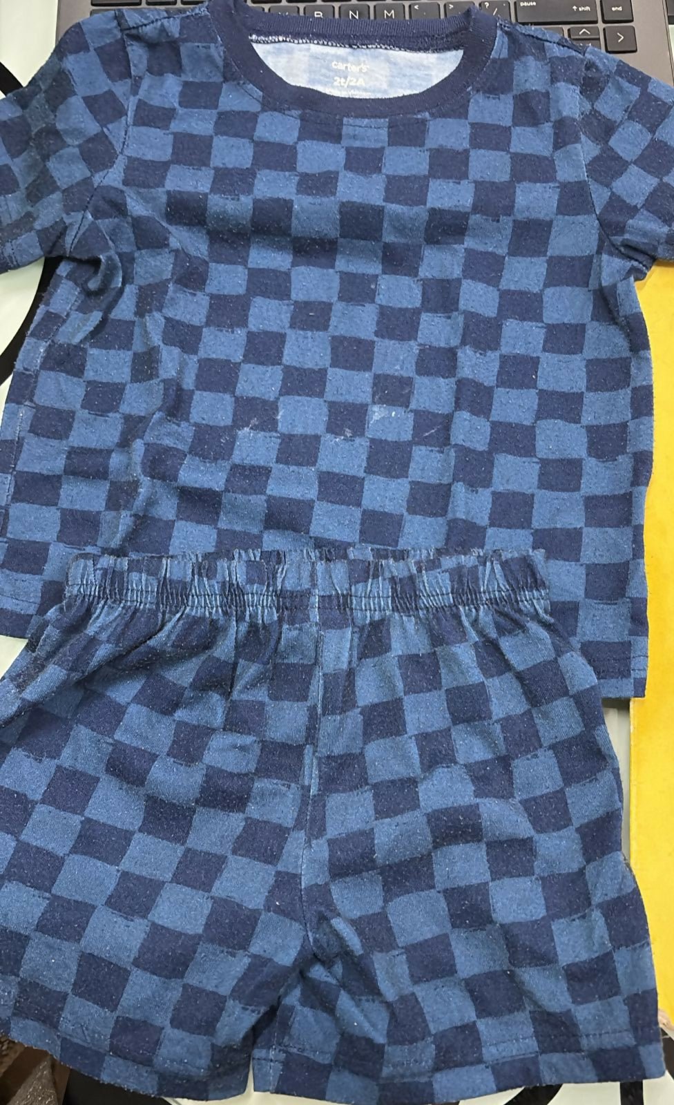 Blue checkered outfit with shirt and shorts on a yellow background
