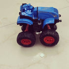 Blue toy truck with large wheels on a light-colored floor
