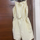 Light yellow romper hanging on a wooden door
