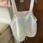 Pastel-colored baby romper on a hanger against a wooden door.