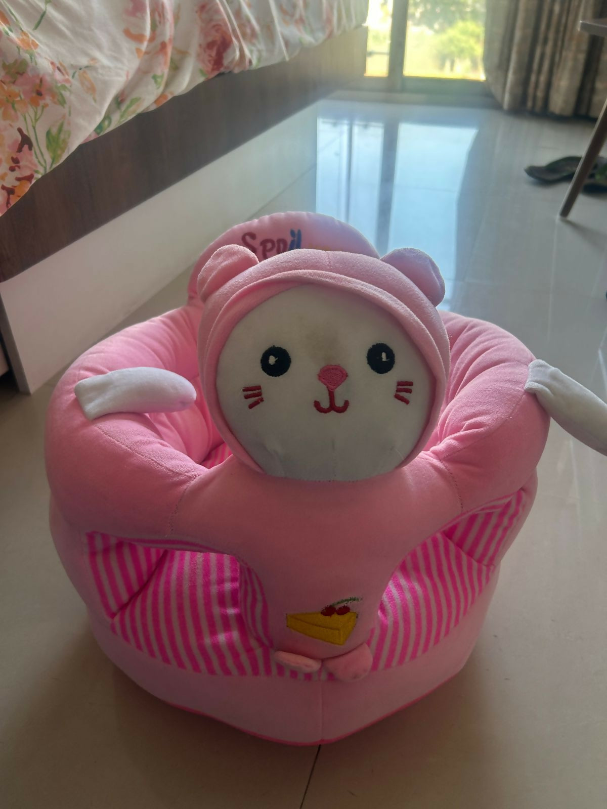 Pink cartoon character seat on a floor
