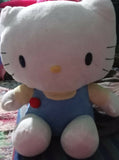 Plush toy resembling a character with a blue outfit and red bow tie on a textured surface.