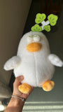 Plush toy penguin held by a hand with a blurred background