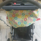 Stroller with a colorful canopy on a marble floor.