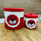 Two red and white woven storage baskets with animal face designs 