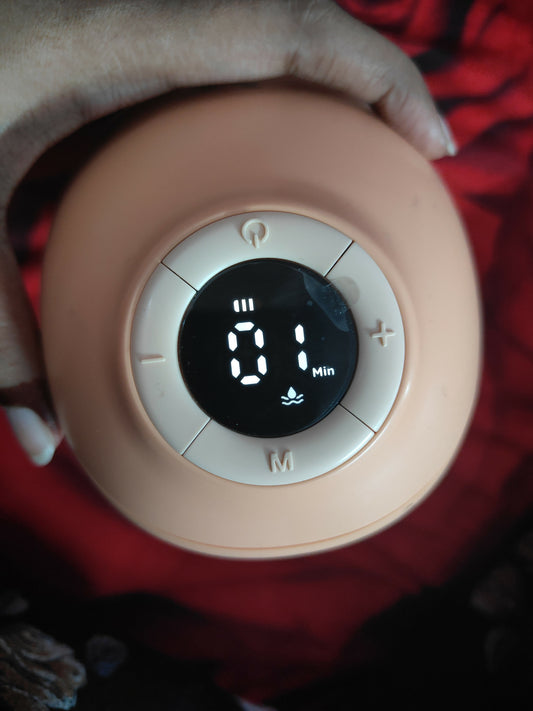 Pink electronic device with digital display held by a hand on a red background