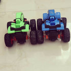 Two toy cars, one green and one blue, on a light-colored floor.