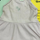 Light gray sleeveless top with embroidery on a green surface