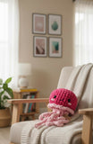Pink crochet octopus toy on a chair with a cozy living room background