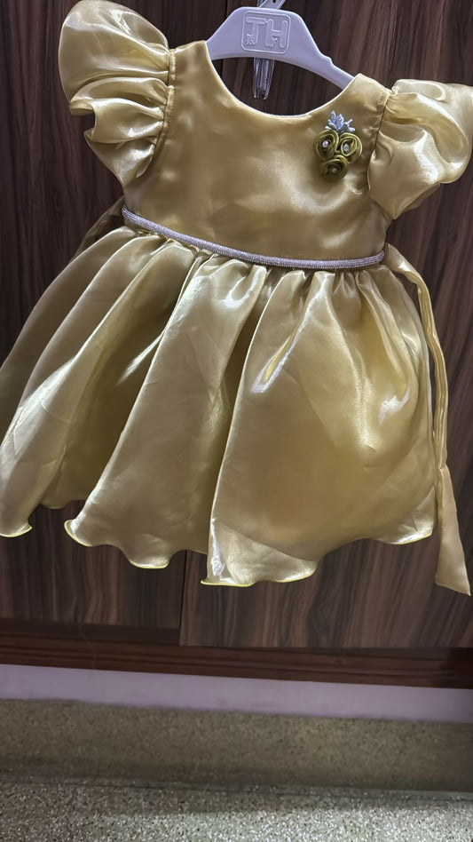 Yellow dress on a hanger against a wooden panel background