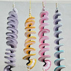 Set of colorful spiral dog toys on a light gray background