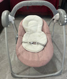 Pink and gray baby swing on a tiled floor