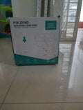 Box of a folding washing machine on a tiled floor