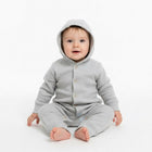 Baby wearing a gray onesie with a hood 