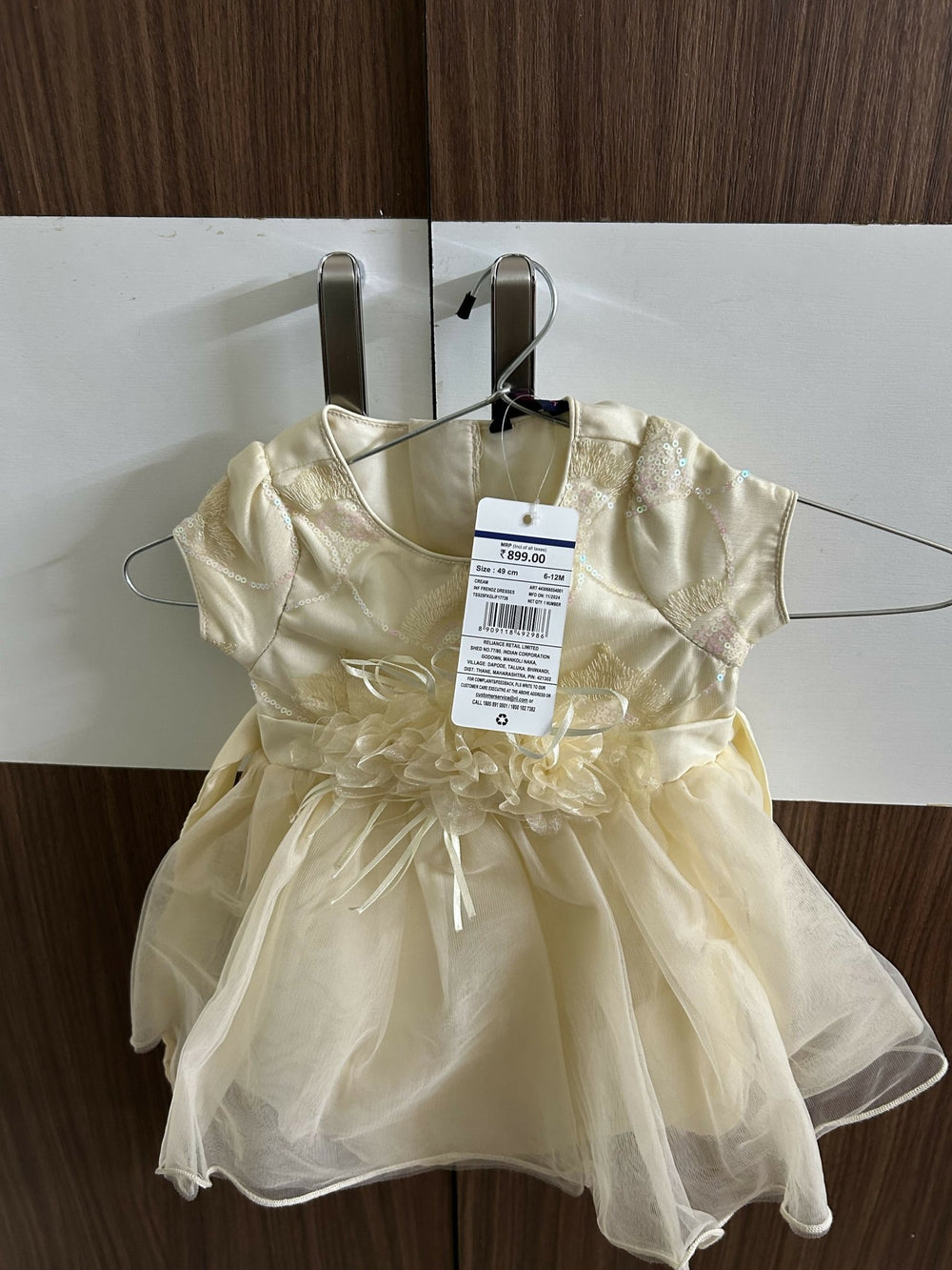 Gold dress on a hanger with a tag 