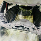 Open suitcase with clothes and a map on a marble surface