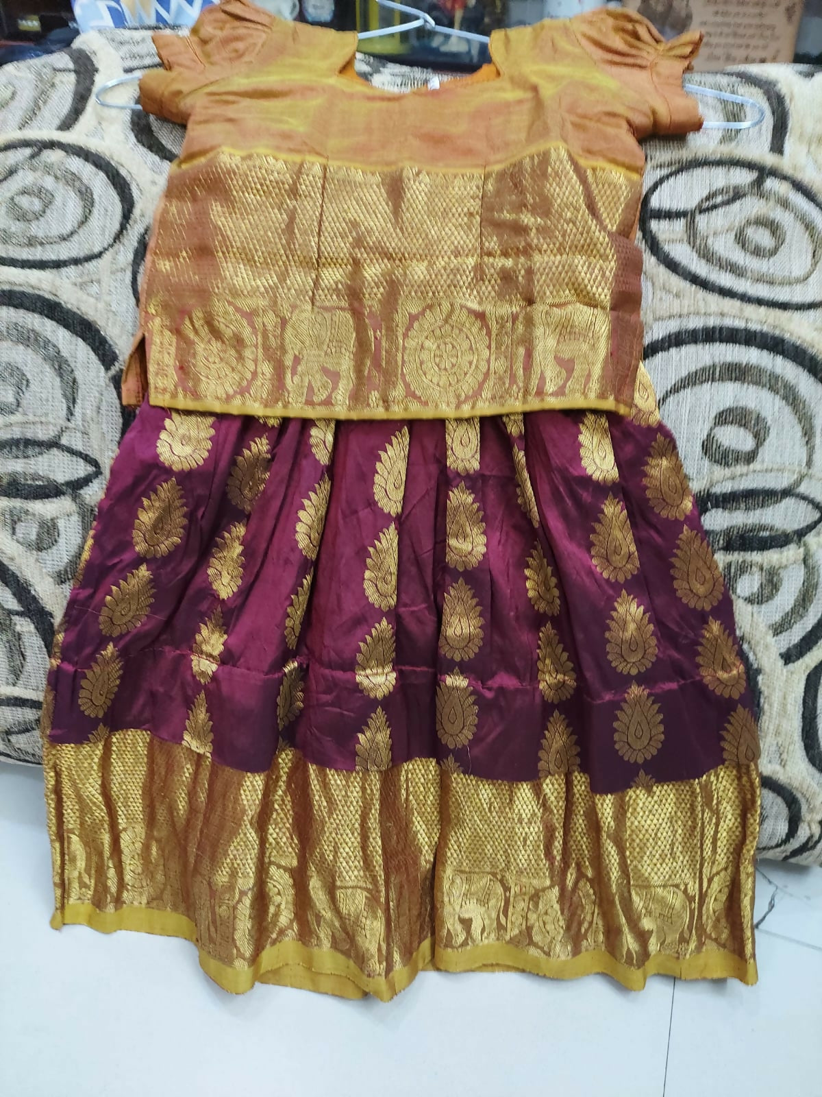 Traditional outfit with a gold blouse and maroon skirt 