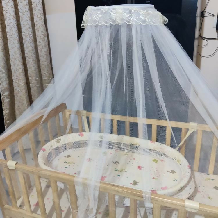 Ensure your baby's comfort and safety with the BABYHUG Kelly Wooden Crib/Cot – featuring a detachable bassinet, mosquito net, and smooth-rolling casters for easy mobility and convenience.