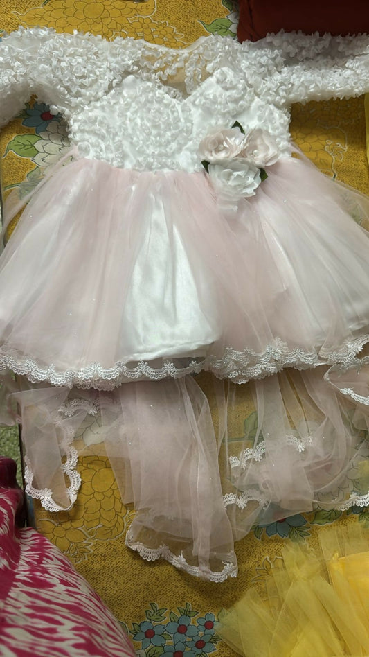 White lace dress with pink tulle on a floral-patterned surface