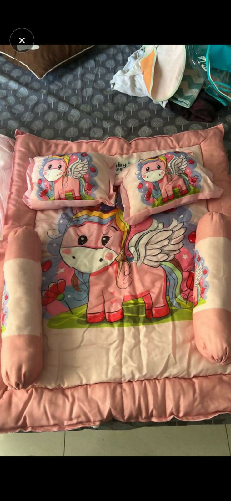 Pink blanket with cartoon horse design and matching pillows 