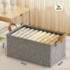 Gray storage basket with handles containing rolled-up items, placed on a bed with measurements indicated.