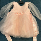 Pink dress with floral details and tulle sleeves on a blue textured background