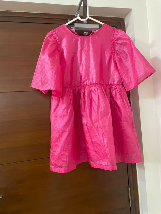 Pink dress hanging on a wooden door