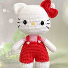 Crocheted toy resembling a character with a red bow and white outfit on a light background