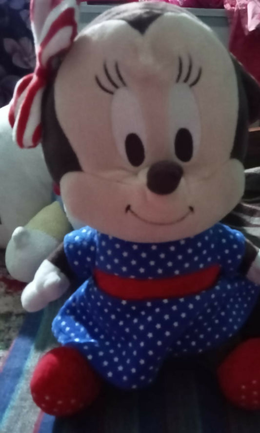 Plush toy resembling a character with a candy cane on top of its head, wearing a blue outfit with white polka dots and a red belt.